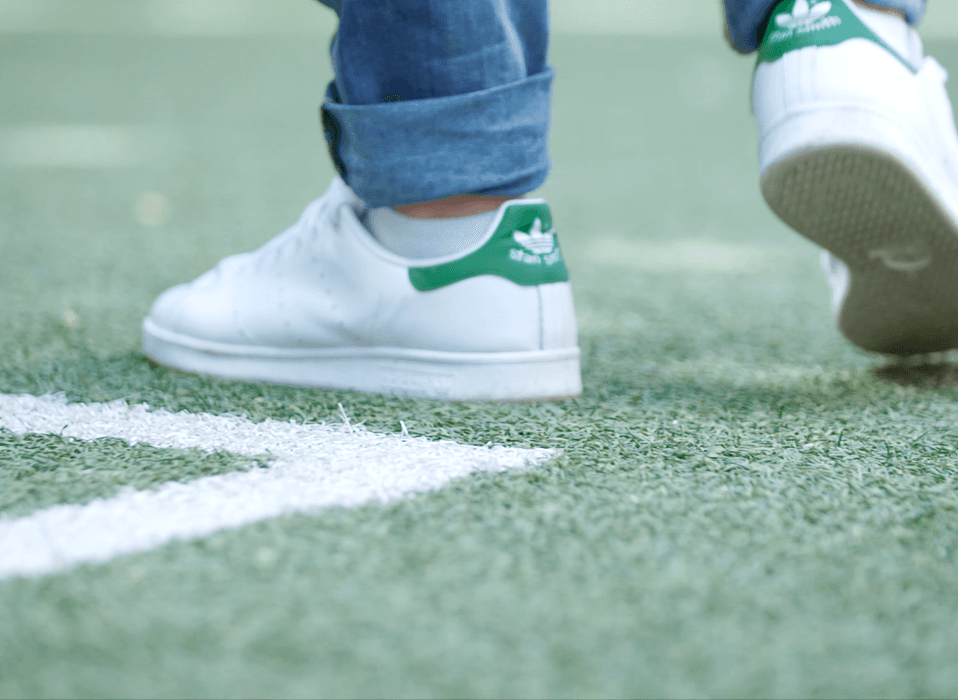Inzoomade sneakers på en fotbollsplan