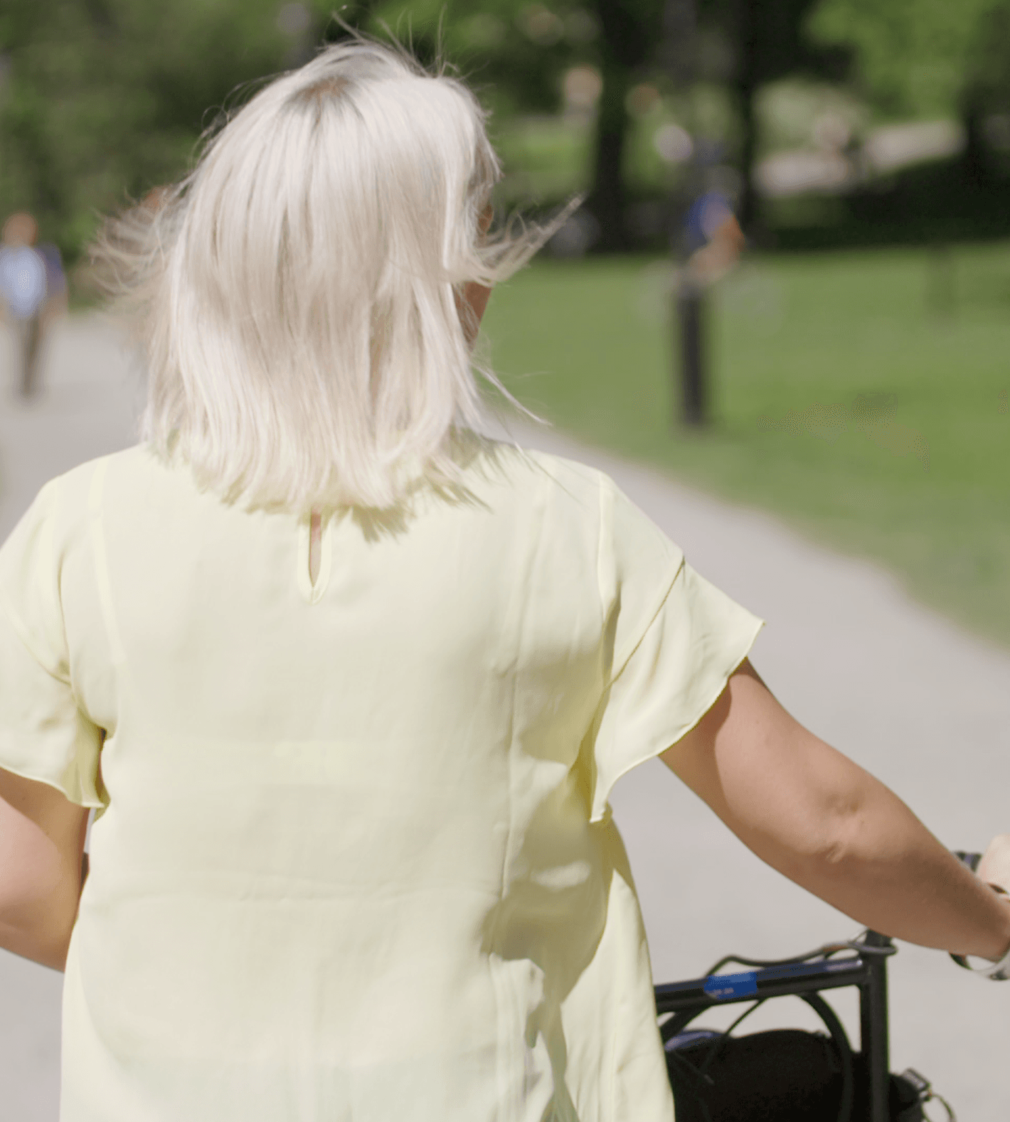 Kvinna med cykel i park