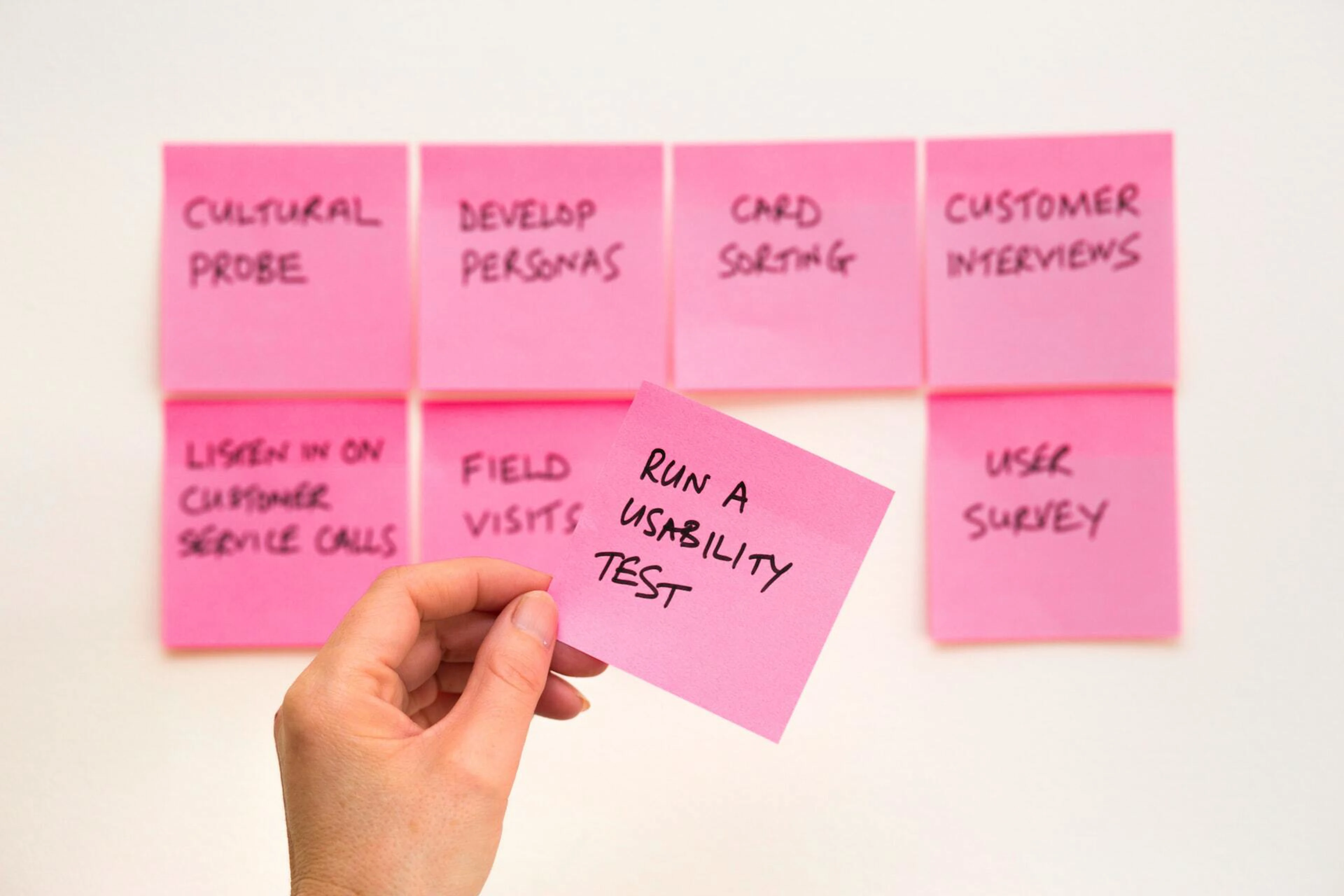 Hand som håller post-it med text: Run a usability test