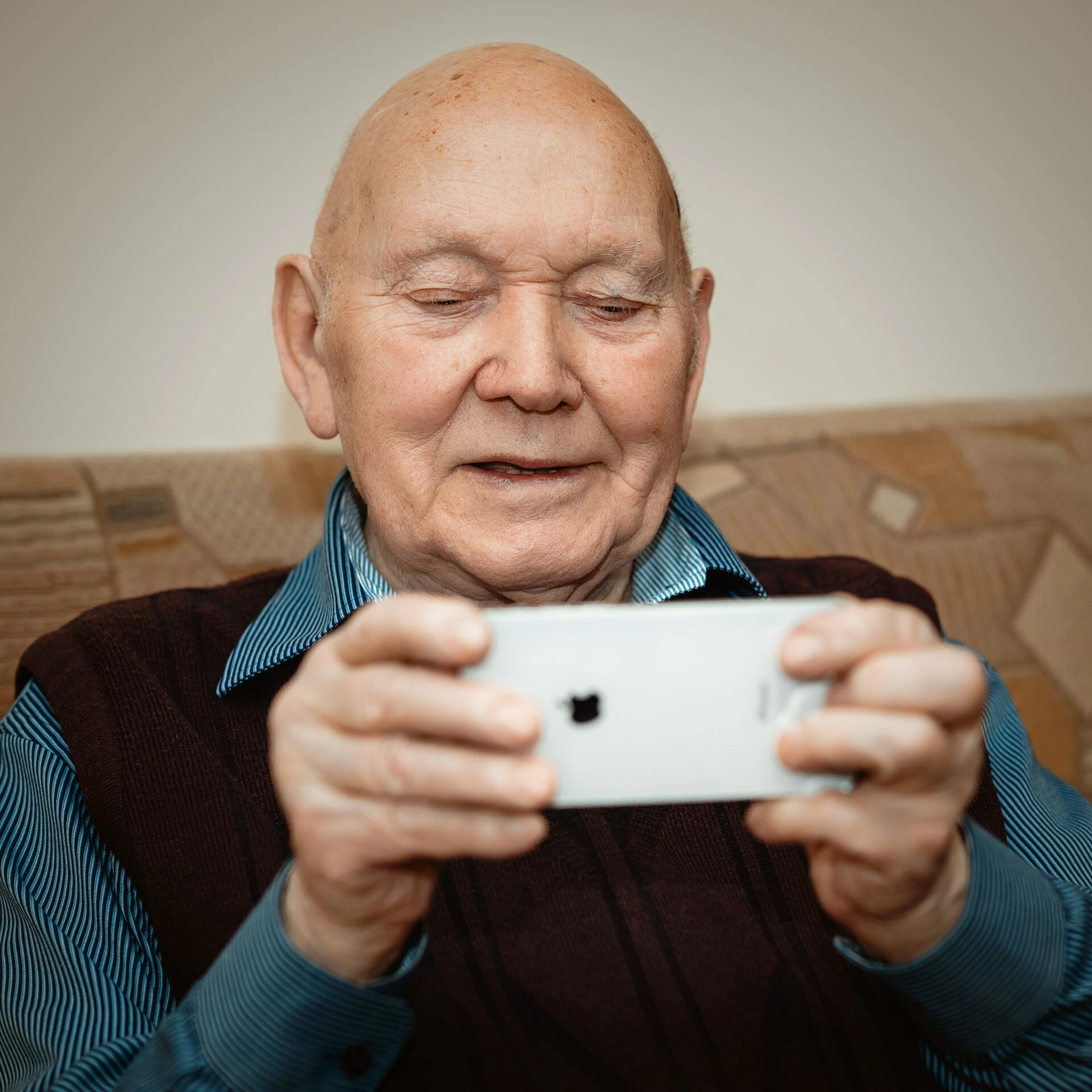 Äldre man håller i en telefon