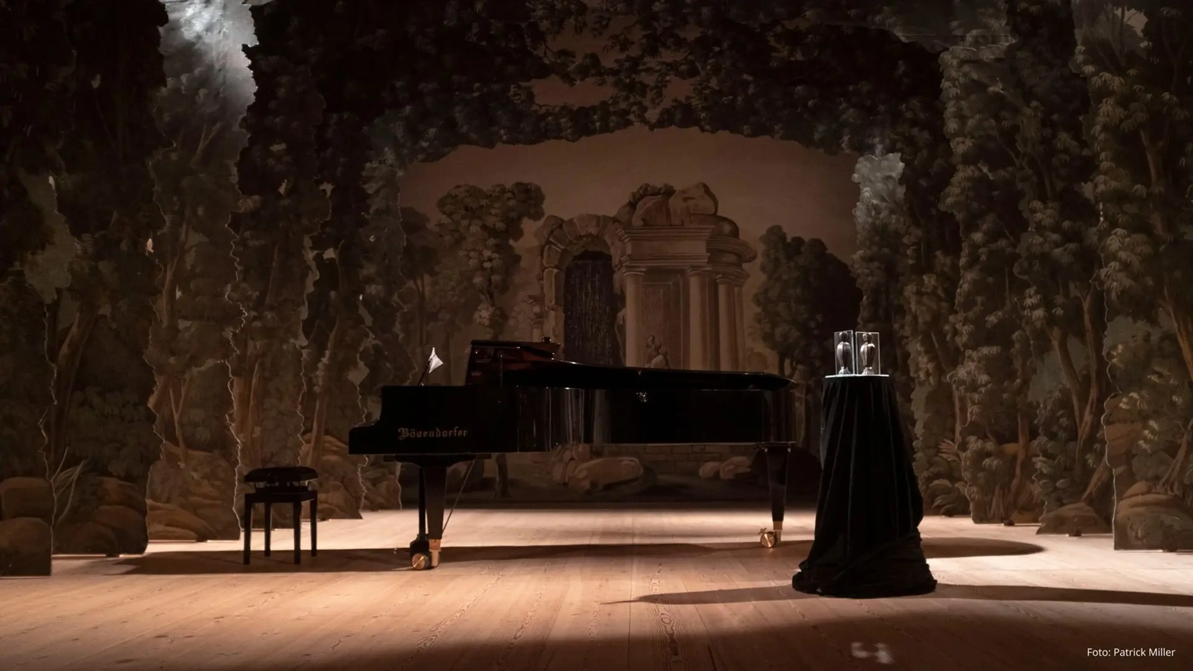 Ett piano på ett golv med mörka kulisser
