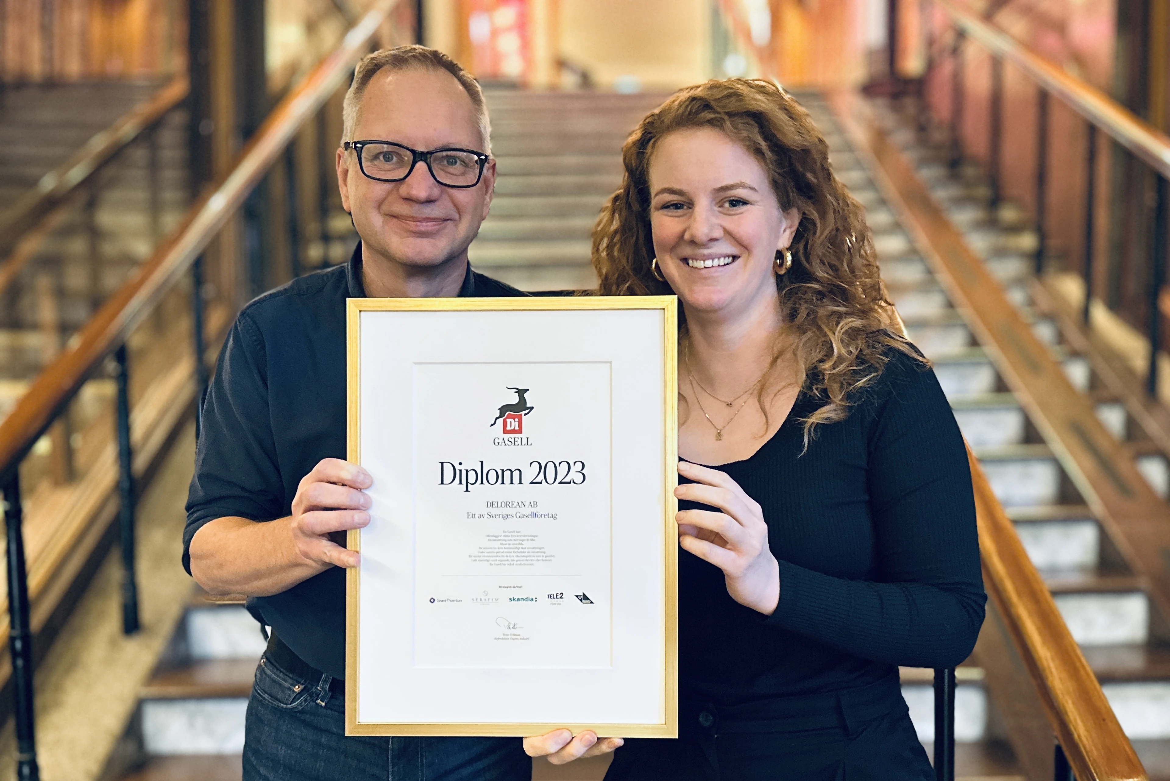 Kvinna och man håller i ett diblom i en trappa