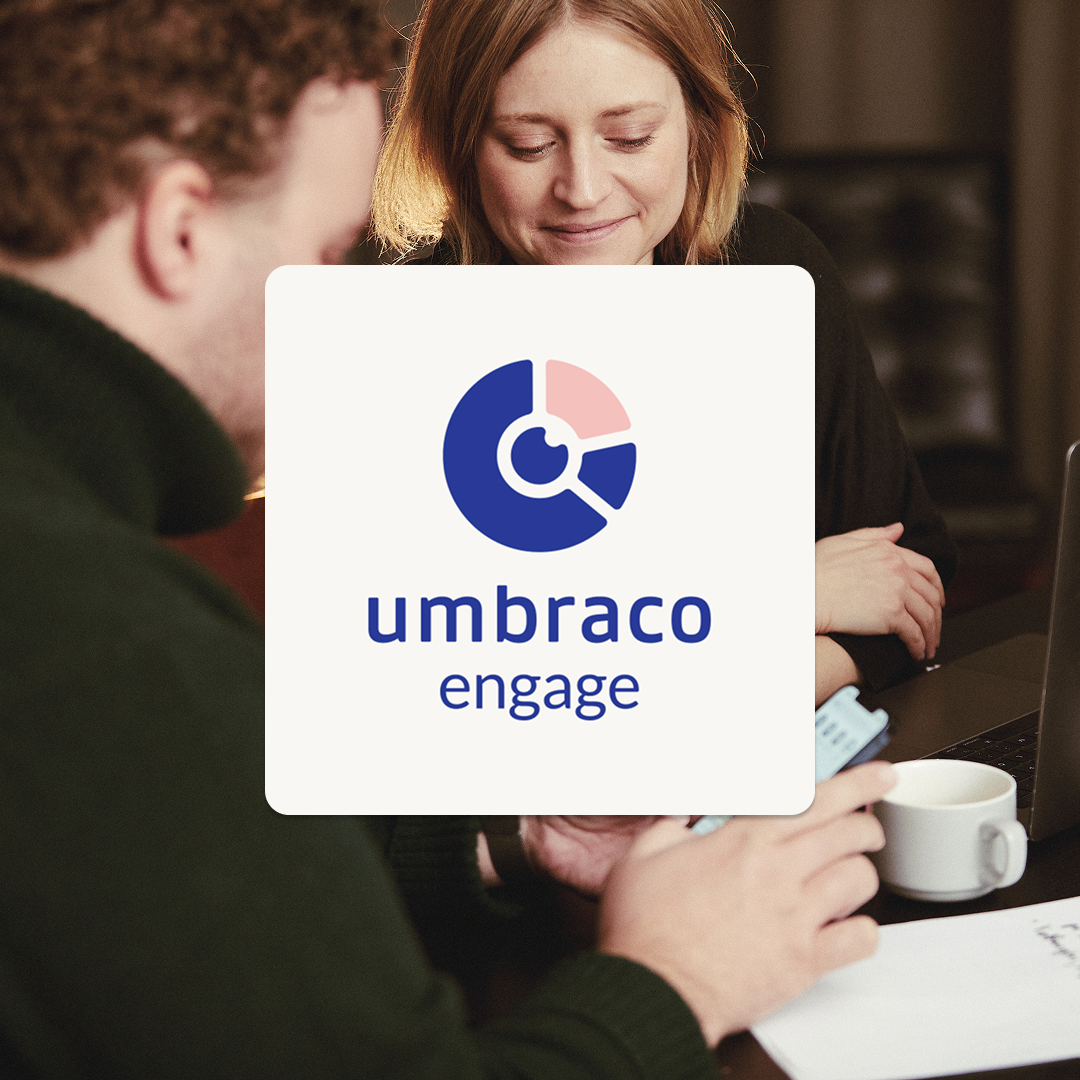 Umbraco Engages logotyp ovanpå en bild på en man och kvinna vide ett bord