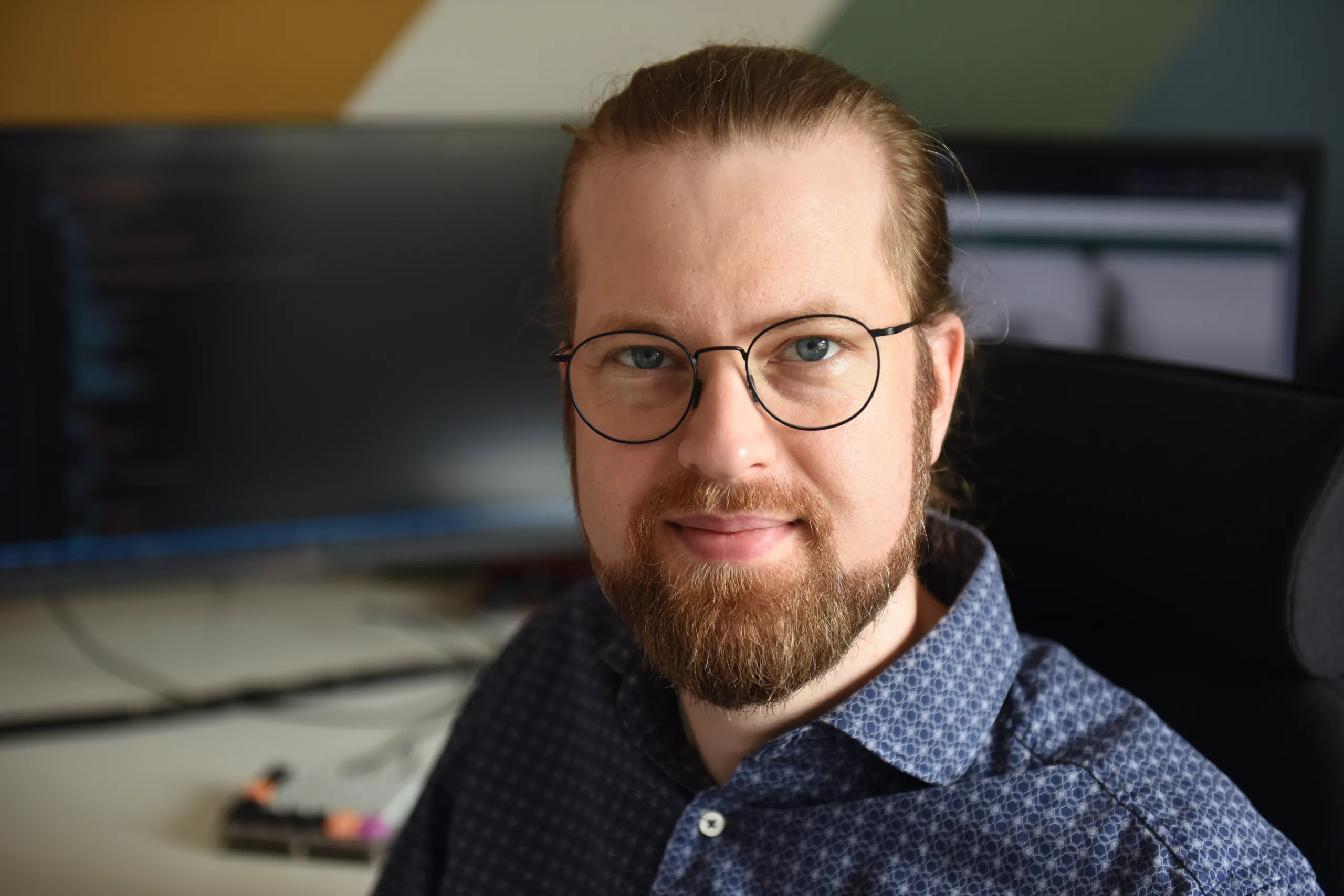 Man med glasögon tittar in i kameran