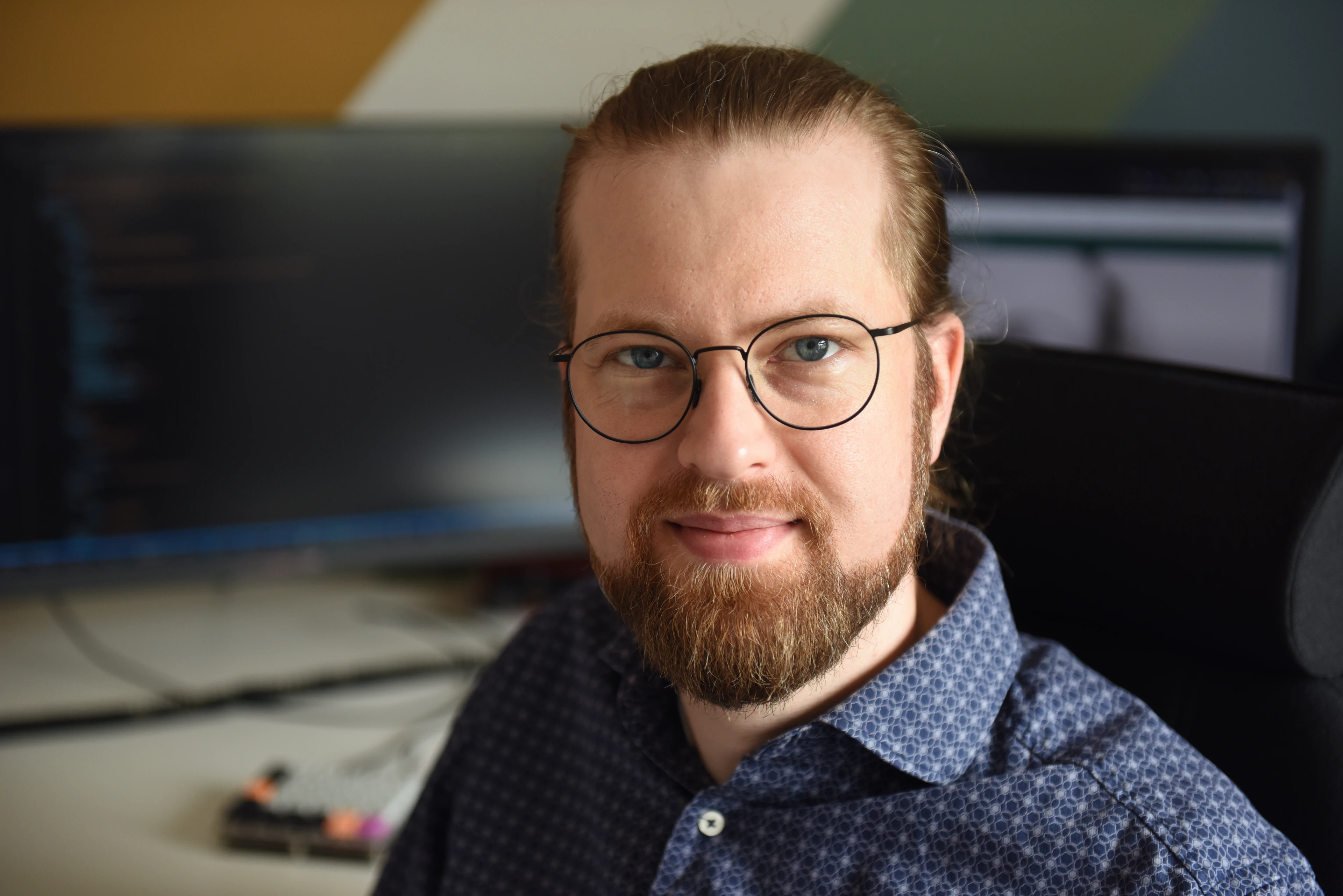 Man med glasögon tittar in i kameran